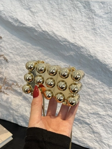 Nahaufnahme der goldenen Acryl-Minikupplung mit 3D-Kugelstruktur und Schlangenkette