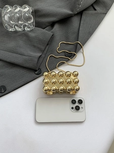 Detaillierte Draufsicht der goldenen metallischen Mini-Tasche mit Perlen und feiner Kette