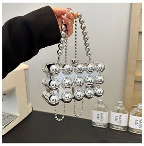 Detail of silver mirror beaded evening bag with glossy sphere texture and metallic finish