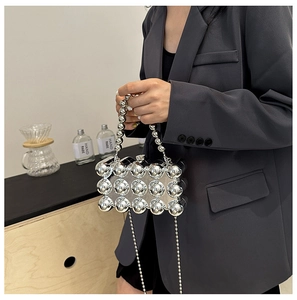 Detail of silver metallic egg-shaped bag with textured surface and beaded chain handle