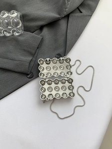 Detailaufnahme der silbernen Acryl-Minitasche in Eiform mit Schlangenkette und Spiegeleffekt