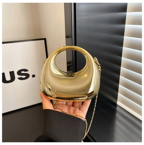 Close-up of circular gold mirror evening bag with integrated handle and bead chain