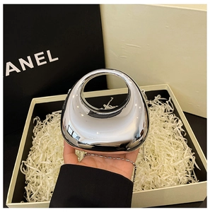 Detail of silver acrylic evening bag with mirror finish and round top handle