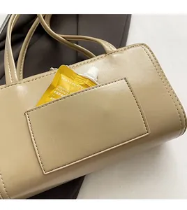 Detail view of the back anti-theft pocket on the minimalist beige PU leather shoulder bag