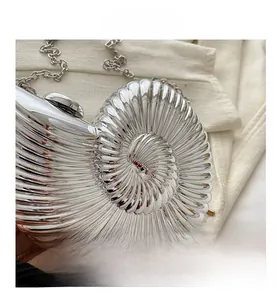 Vue détaillée d'une pochette coquillage argentée avec texture spirale et chaîne