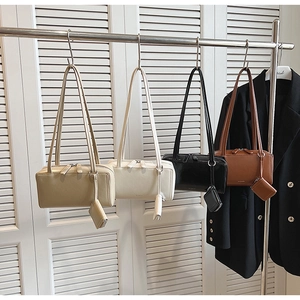 Detail view of four leather shoulder bags in neutral colors with matching coin purses