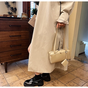 Detail of beige rectangular shoulder bag with slim double straps and a square coin purse