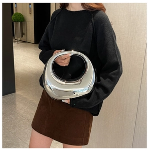 Bolso de mano futurista en acrílico plateado con acabado espejo y diseño de media luna