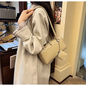 Beige polished leather shoulder bag detail with mini pouch attachment shown on model