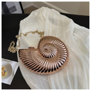 Détail de la pochette de soirée en forme de coquillage, or rose avec texture en spirale