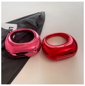 Primer plano de bolsos de acrílico metálico en rosa y rojo con asas redondas integradas