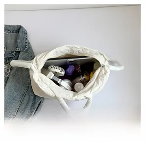 Detailed interior view showing large capacity of the white padded tote bag with daily items