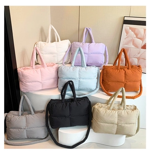 Détail de sacs cabas matelassés en huit couleurs présentés sur un support d'exposition