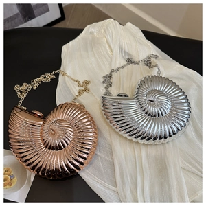 Vue détaillée des sacs de soirée coquillage en argent et or rose sur tissu de soie