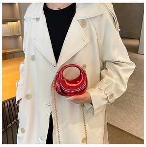 Chic metallic red mini moon bag with gold chain strap shown on an elegant outfit