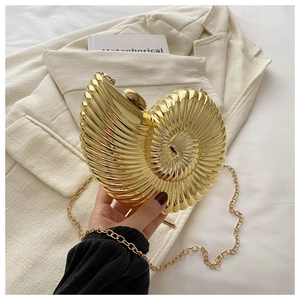 Gros plan détaillé d'une pochette en acrylique dorée en forme de coquille à texture spirale