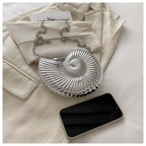 Pochette coquillage argentée avec chaîne à côté d'un smartphone pour comparer la taille