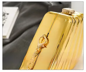 Detail shot of the gold chain clasp on a luxury metallic textured gold evening bag