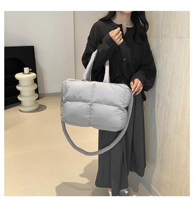 Detail view of the gray quilted down tote bag with padded handles and large grid stitching