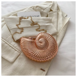 Détail du sac de soirée en forme de conque or rose avec texture spirale et bandoulière