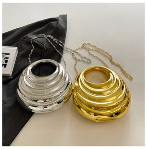 Detail of elegant gold and silver crescent evening bags with metallic ripple texture