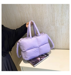 Detail of light purple quilted puffer tote bag with zipper closure and soft padded texture