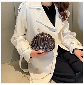 Detail view of the brown seashell evening bag with gold chain and glossy shell texture