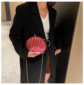 Chic rose pink shell clutch with gold chain strap shown against a modern interior