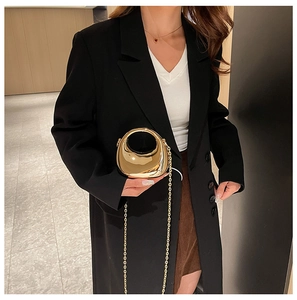 Detailed view of mini golden bean-shaped metal evening bag with glossy mirror finish