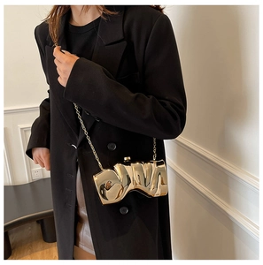 Chic gold irregular pleated clutch bag with metallic texture shown on a black blazer