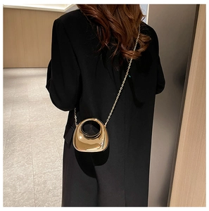 Detailed back view of a mini gold crossbody bag with chain strap and hollow handle