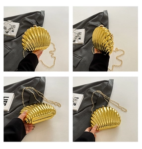 Detail of golden shell-shaped evening bag showing metallic texture and chain strap