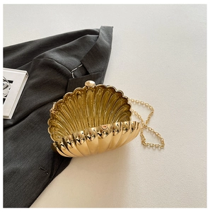 Detail of a golden shell evening clutch with metallic texture and sleek chain strap