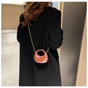 Back view of pink mirror acrylic crescent mini bag with gold chain strap on shoulder