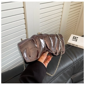 Detail of metallic wavy evening clutch with purple gold finish and silver twist lock