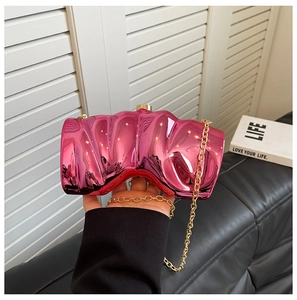 Detail of rose red metallic evening clutch bag with unique pleated texture and gold chain