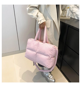 Detail view of pink quilted nylon tote bag with plush square stitching and crossbody strap