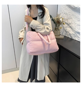 Fashionable pink quilted nylon puffer tote bag shown as lifestyle crossbody wear