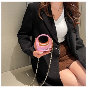 Detail of mini pink metallic crescent bag with golden chain and mirror finish