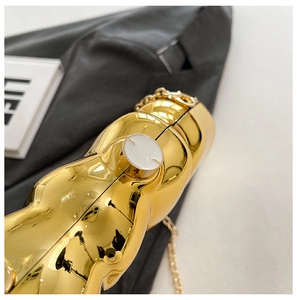 Detail of bear-shaped golden electroplated evening bag with shiny metallic mirror finish