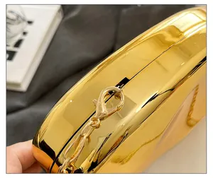 Dettaglio macro di finiture dorate e maglie di catena su una borsa da sera di lusso