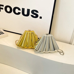 Metallic pleated chain evening bags in gold and silver colors on a minimalist display stand