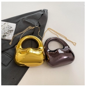 Detail view of modern metallic clutch bags in gold and bronze with chic chain straps