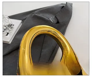 Macro detail of the golden metallic U-shaped handle with a glossy mirror-like finish