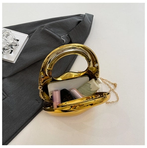 Interior view showing the capacity of a gold evening clutch with a phone and lipstick
