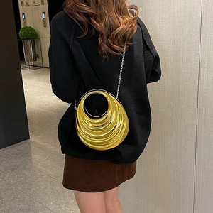 Elegant gold metallic evening clutch with wavy texture and circular handle for party