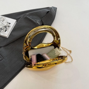 Golden acrylic clutch bag with metal chain showing internal capacity on white background