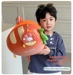 Close-up of orange carrot-shaped backpack with cute bunny pouch and squeaky green leaves