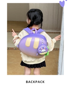 Rear view of a girl wearing the purple gradient bunny backpack with a round coin pouch