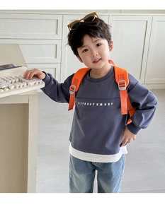 Detail of grey boy's sweatshirt with letter print and layered hem design